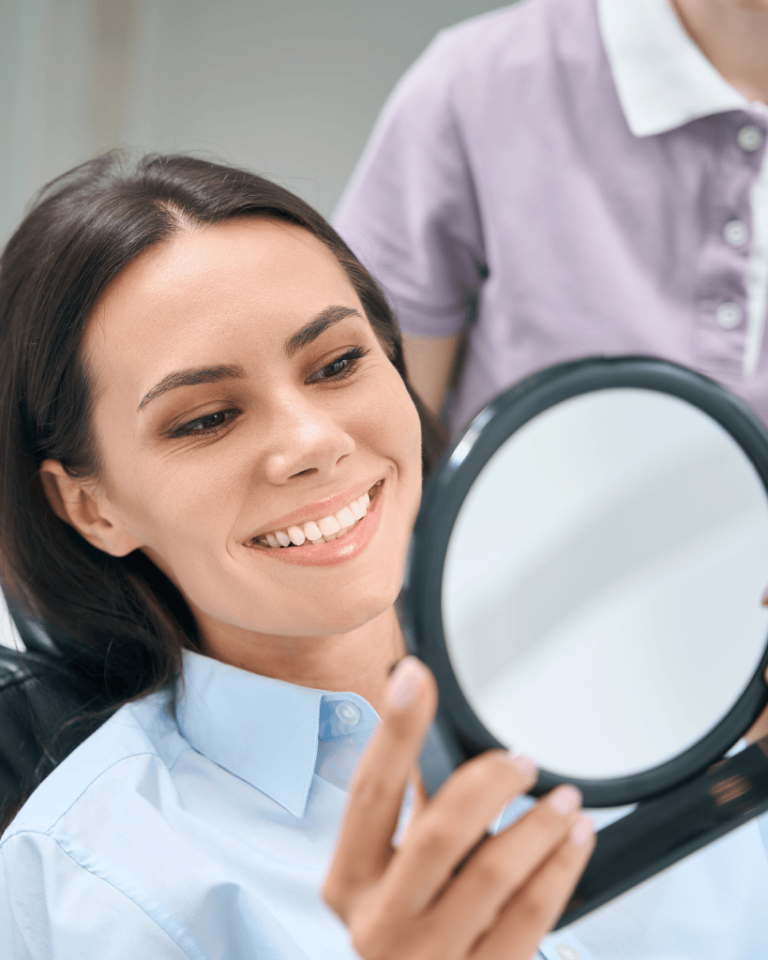 Patient admiring her smile in a hand mirror